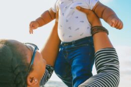 woman holding up baby