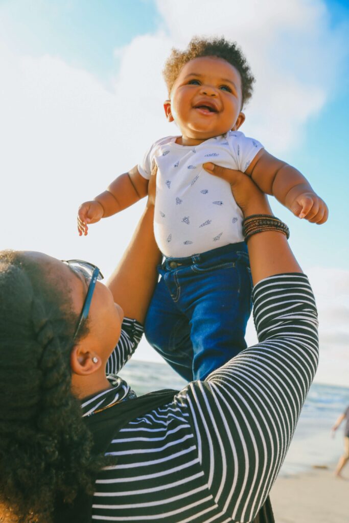 woman holding up baby